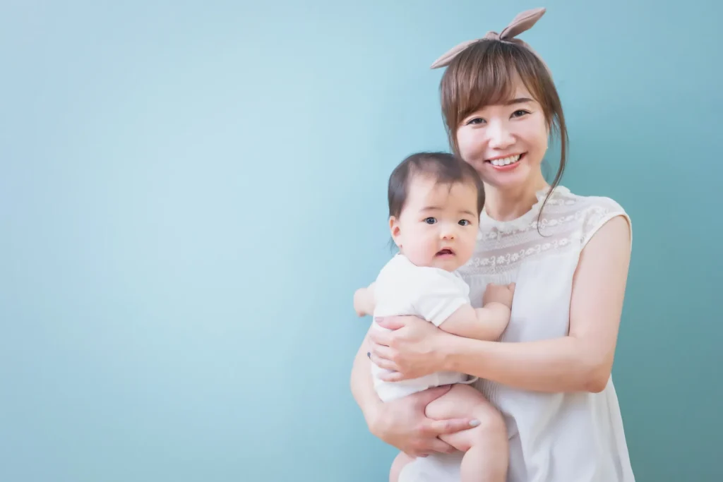 赤ちゃんを抱えて笑顔のお母さん