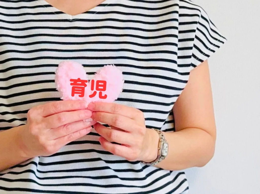 女性の手に持つハート（育児）