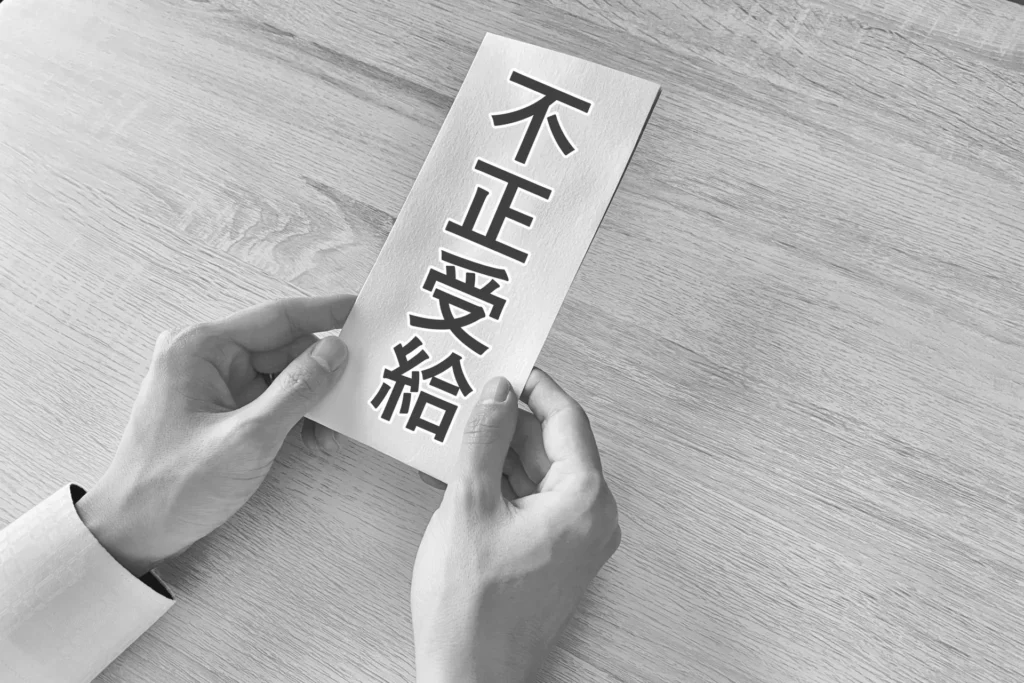 「不正受給」と書いた封筒を差し出す