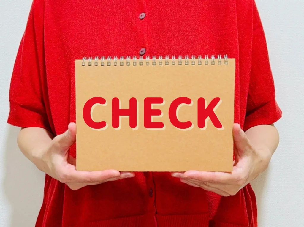 「check」と書いた紙を持つ女性