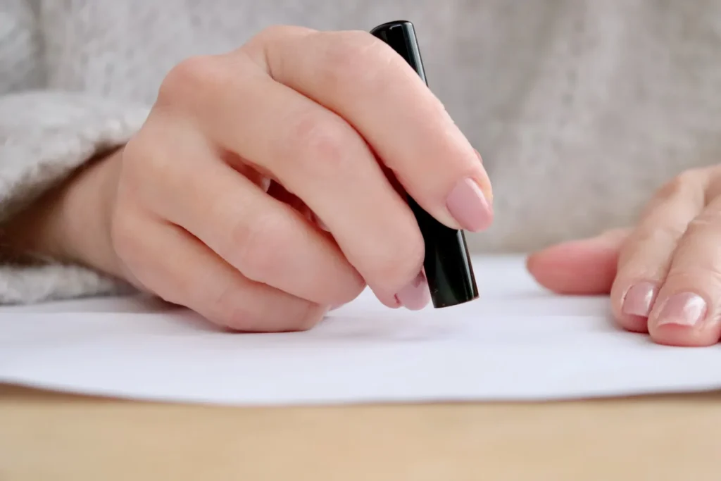 契約書に捺印する女性の手元