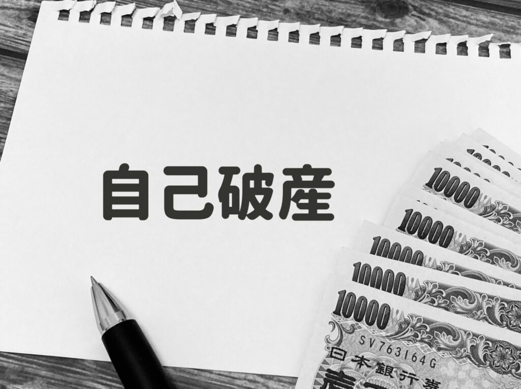 ちぎれたノートの上にペンで自己破産と書かれている
