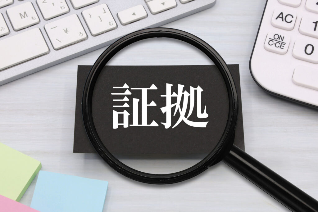 黒い紙に白地で証拠と書かれた紙を黒い虫眼鏡で見ている